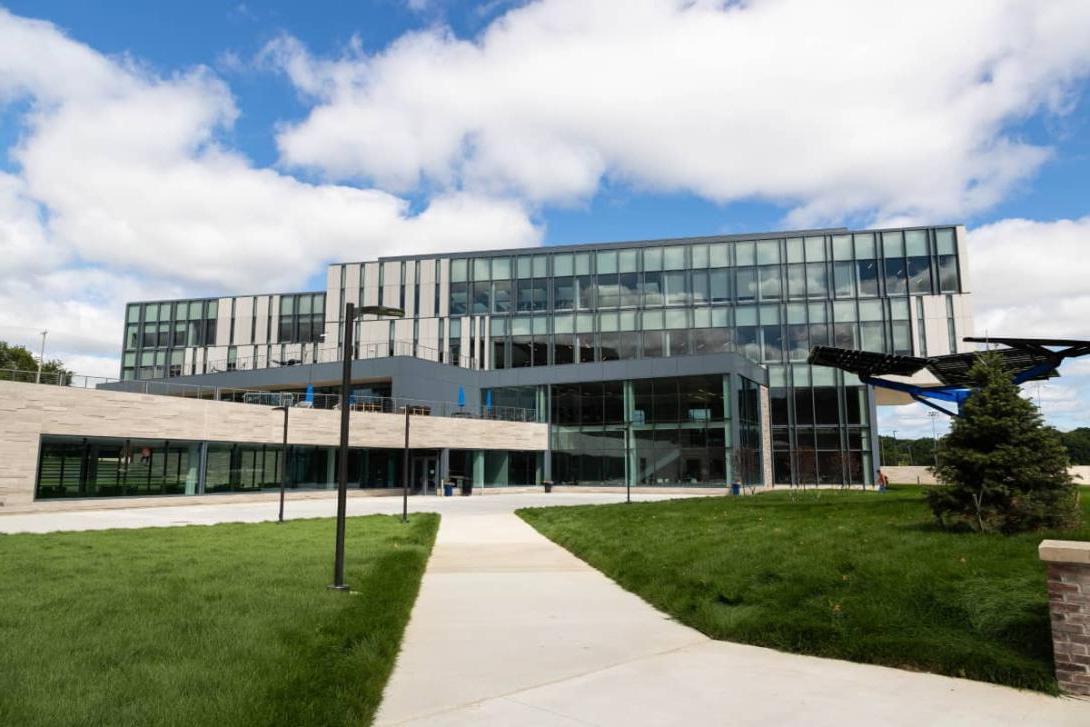 A multi-story glass building on Kettering's campus. In front of the building are grass lawns.